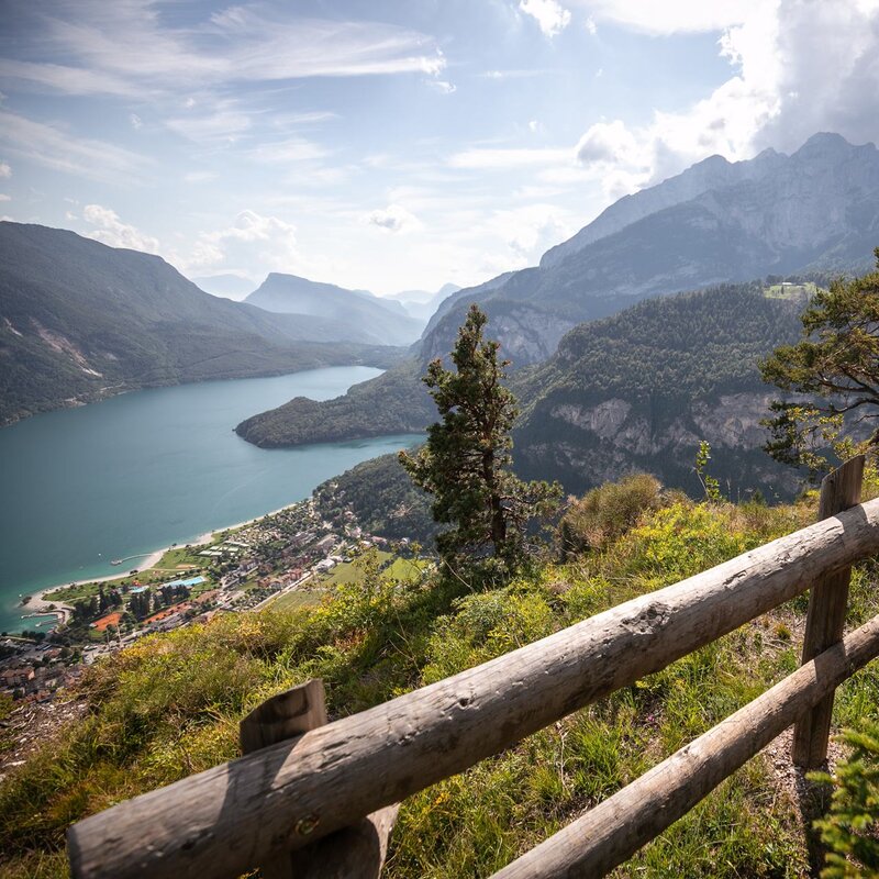 A family overlooks Lake Molveno from the fence on the Mondo di Sciury path on the Pradel plateau | © oliver Astrologo, 2019