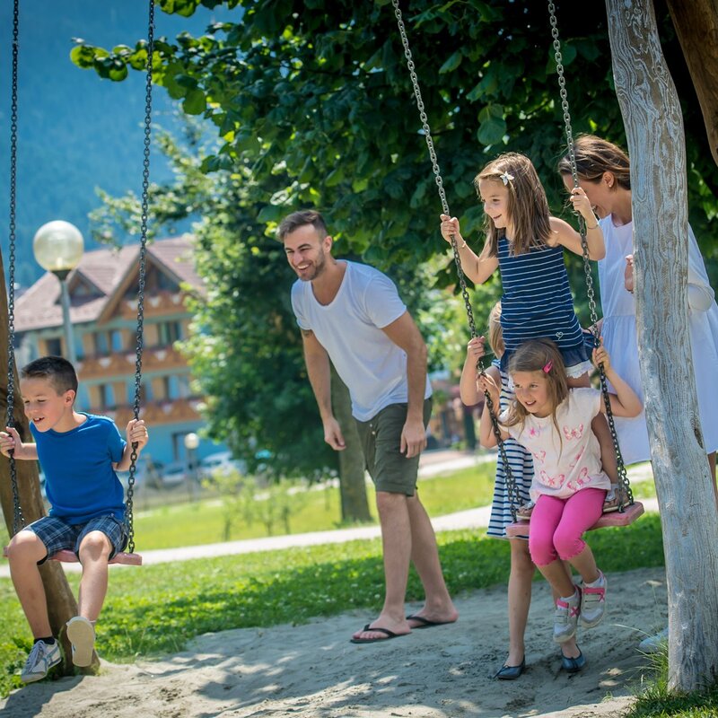 Una famiglia al parco dell'Andalo Life. La mamma e il papà spingono i tre bambini sulle altalene | © Matteo De stefano, 2016