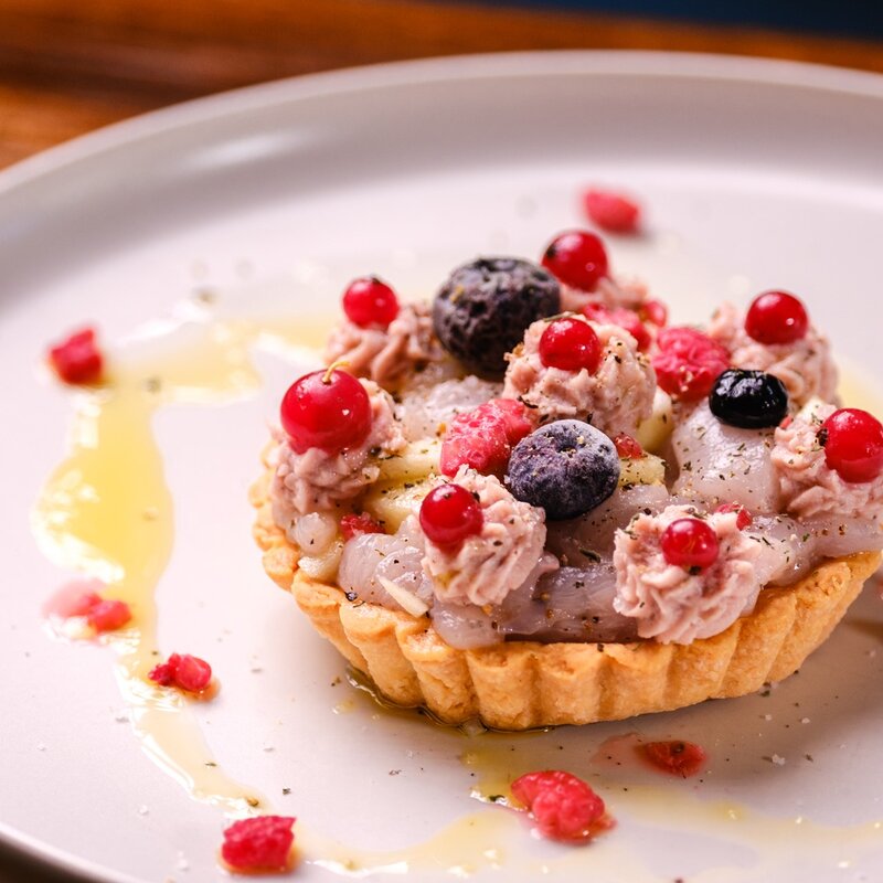 Tartelletta salata al Trentingrana farcita con crema di salmerino, decorata con frutti di bosco freschi e gocce d'olio. | © Stefano Caffarri, 2025