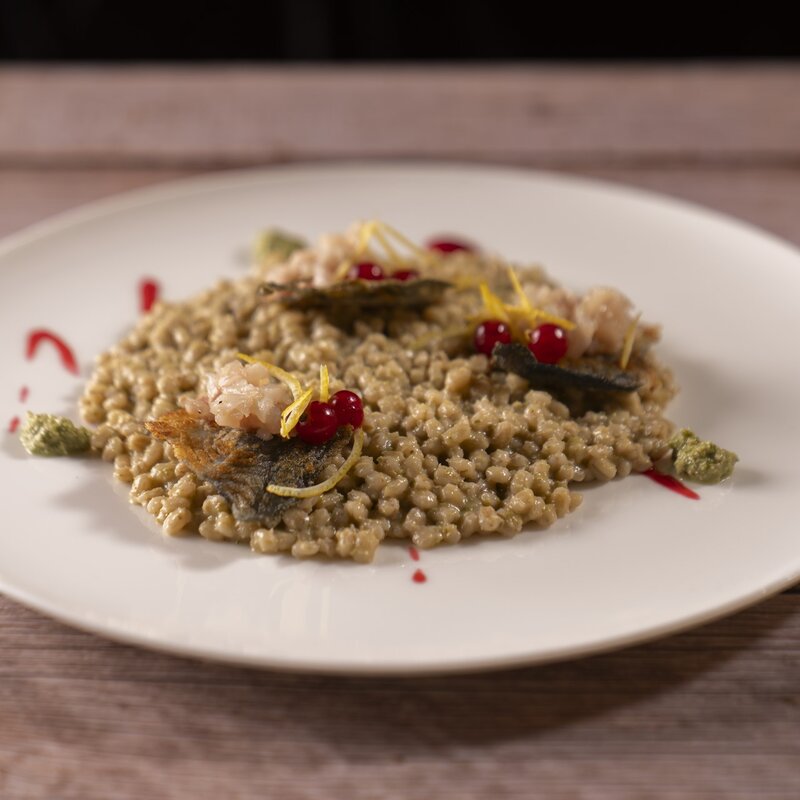 Orzotto all'abete rosso con tartare di salmerino, ribes rossi e scorza di limone. | © Stefano Caffarri, 2025