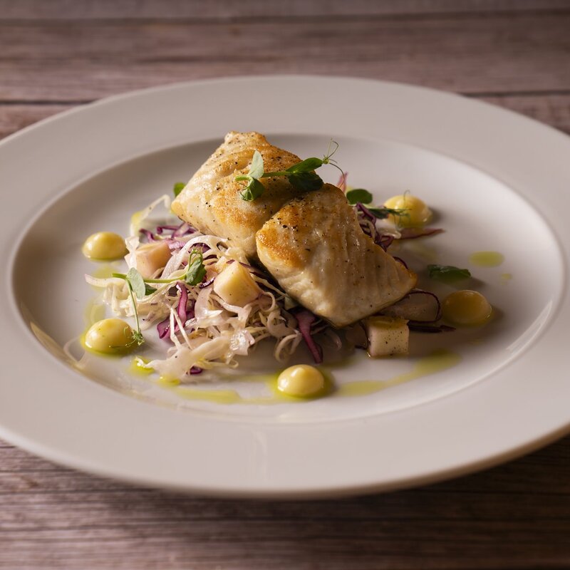 Trancio di salmerino flambato alla grappa con cavolo cappuccio, mele e dressing all'olio di oliva del Garda.  | © Stefano Caffarri, 2025