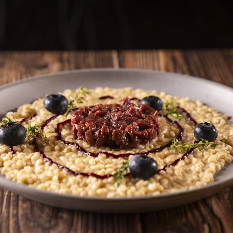 Juniper-scented Orzotto with Venison tartare and a Teroldego Rotaliano and Uncle John's honey reduction. | © Stefano Caffarri, 2025