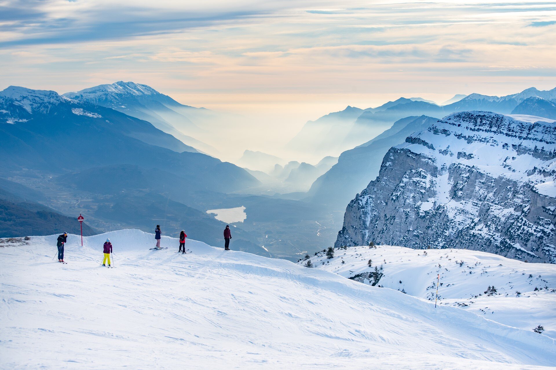 From the top of Paganella some skiers admire the view that reaches Lake Garda | © Giorgio Monticelli, 2020