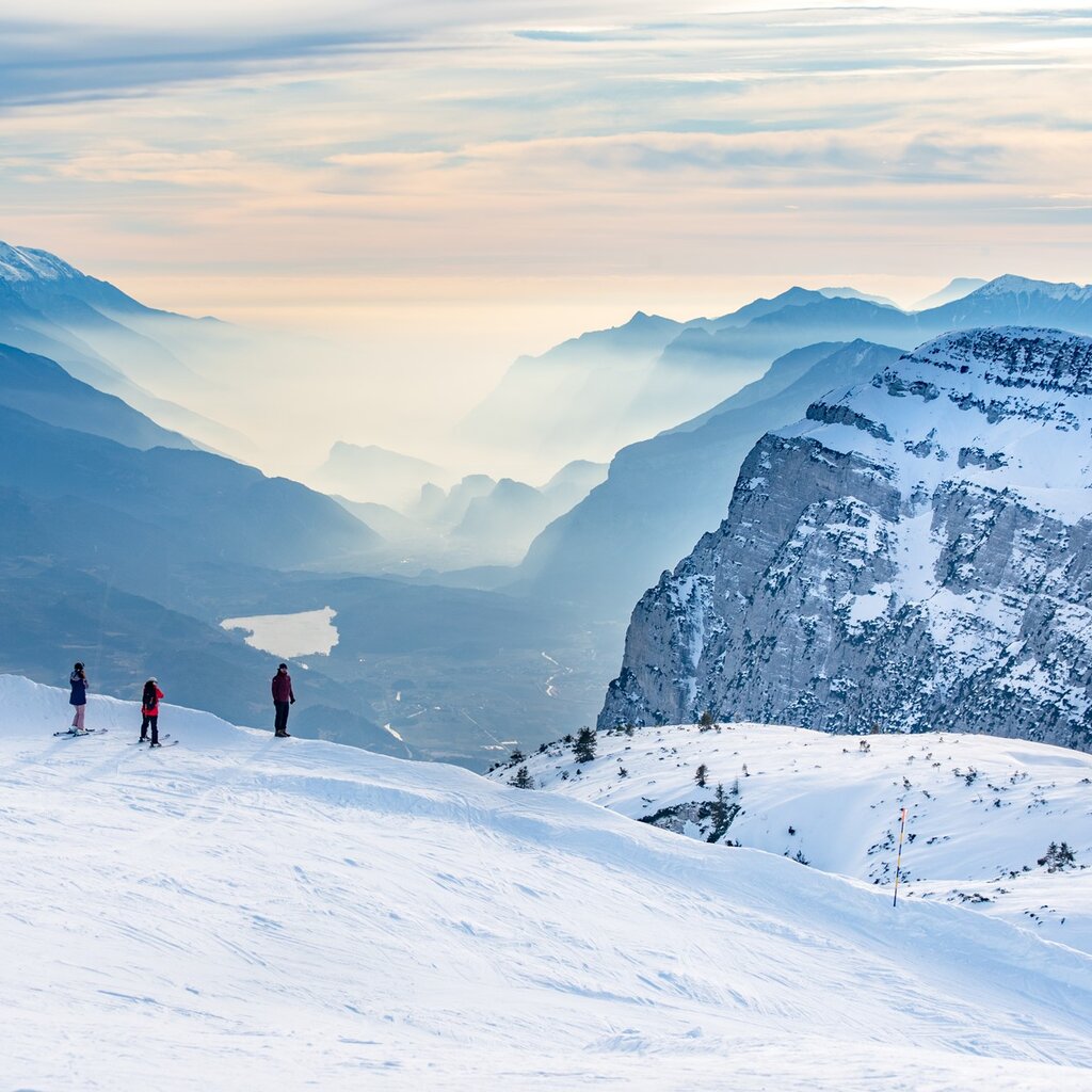 From the top of Paganella some skiers admire the view that reaches Lake Garda | © Giorgio Monticelli, 2020