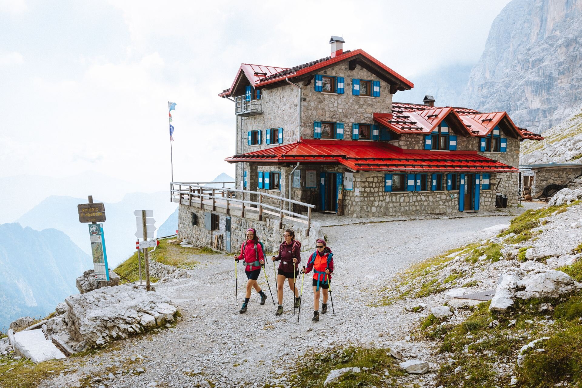 Tre ragazze camminano con bastoncini da trekking davanti al rifugio Agostini, nel cuore delle Dolomiti di Brenta | © Nicola Cagol, 2021