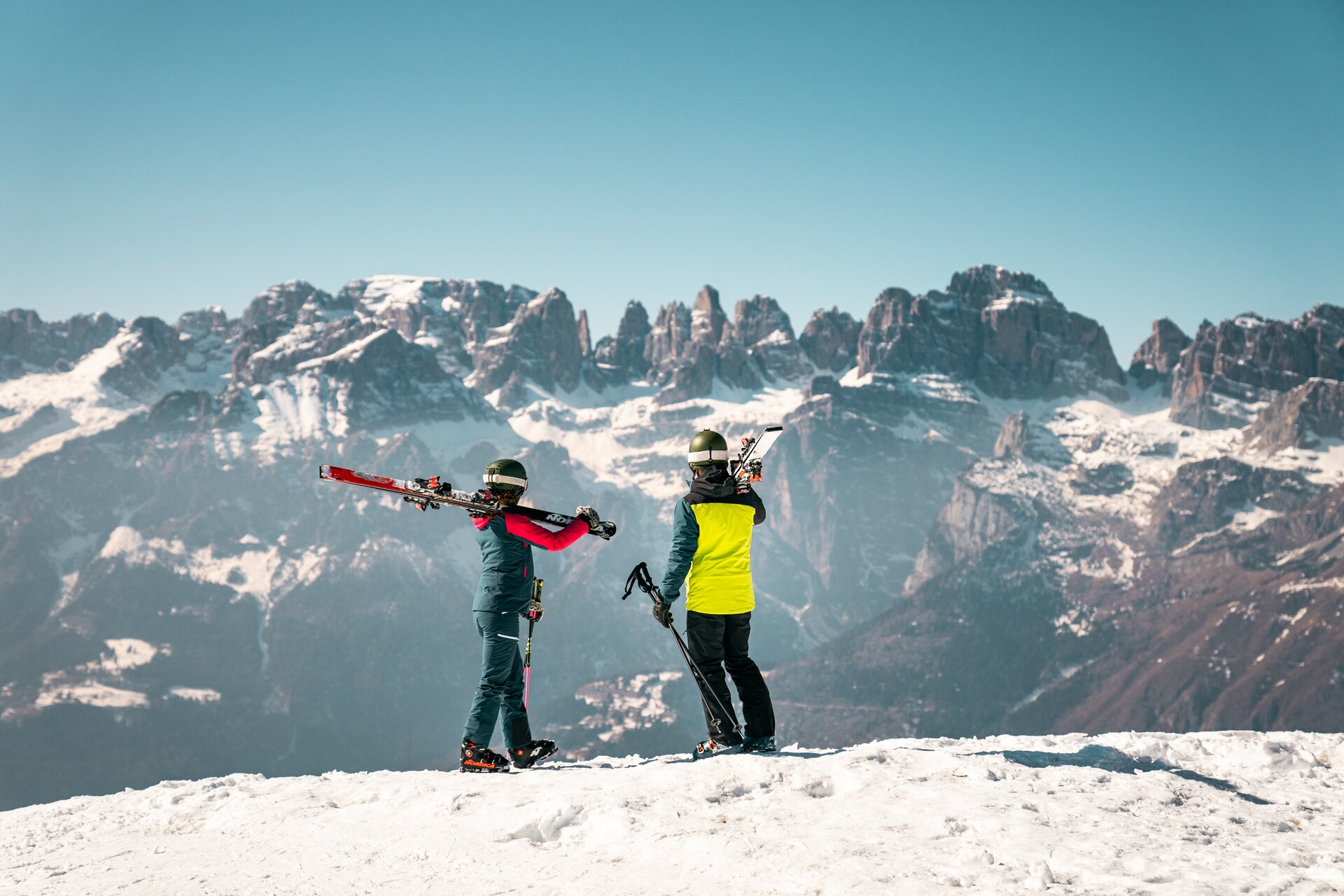 Two skiers on the slopes of Paganella admire the Brenta Dolomites in front of them | © Camilla Pizzini, 2022