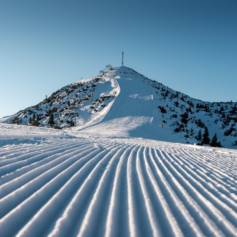 Ski slope with a view of the Paganella peak and ski tracks. | © Filippo Frizzera, 2022