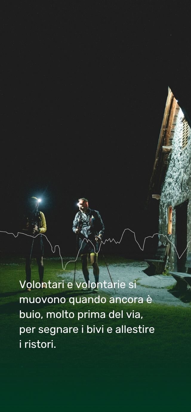 Immagine verticale notturna che mostra due volontari con torce frontali accanto a una baita in pietra. Una grafica a linea bianca (profilo altimetrico) attraversa la foto. Il testo recita "Volontari e volontarie si muovono quando ancora è buio, molto prima del via, per segnare i bivi e allestire  i ristori.". | © Filippo Frizzera, 2025