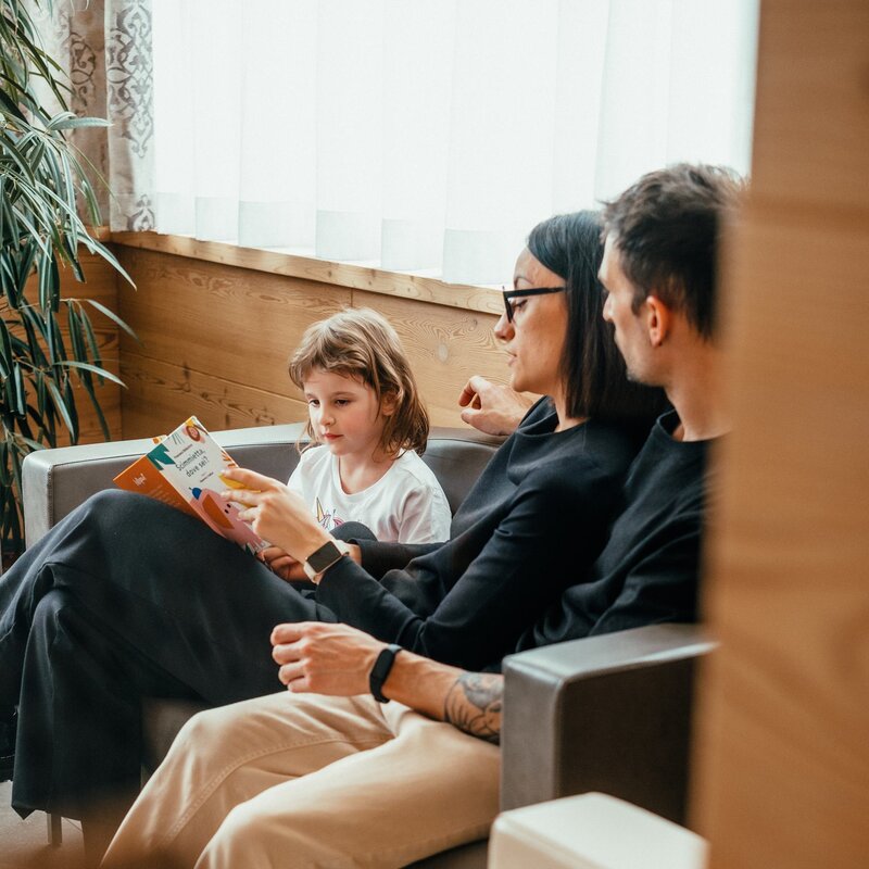Beatrice, Matteo and daughter Dalia read a book on the sofa  | © Frame & Work, 2024