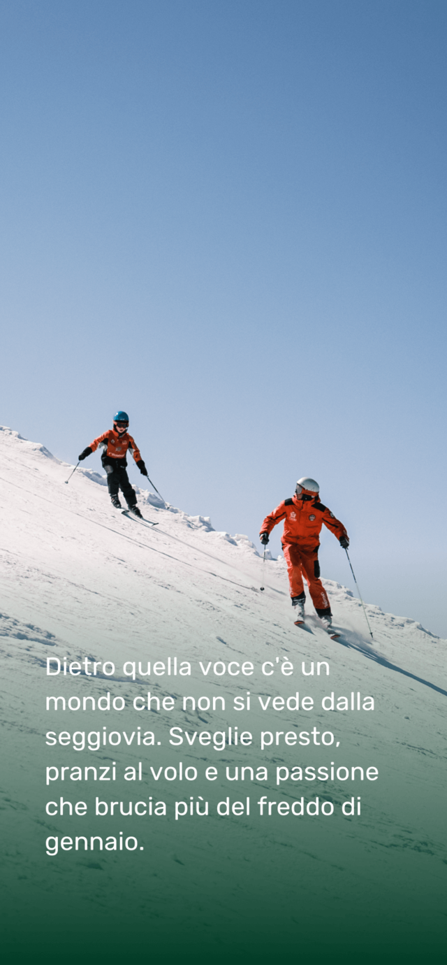 Un maestro di sci in divisa rossa e un bambino in tenuta simile scendono su un ripido pendio innevato, lasciando tracce sulla neve fresca sotto un cielo azzurro e terso.  Testo in sovrimpressione: Dietro quella voce c’è un mondo che non si vede dalla seggiovia. Sveglie presto, pranzi al volo e una passione che brucia più del freddo di gennaio. | © Filippo Frizzera, 2025
