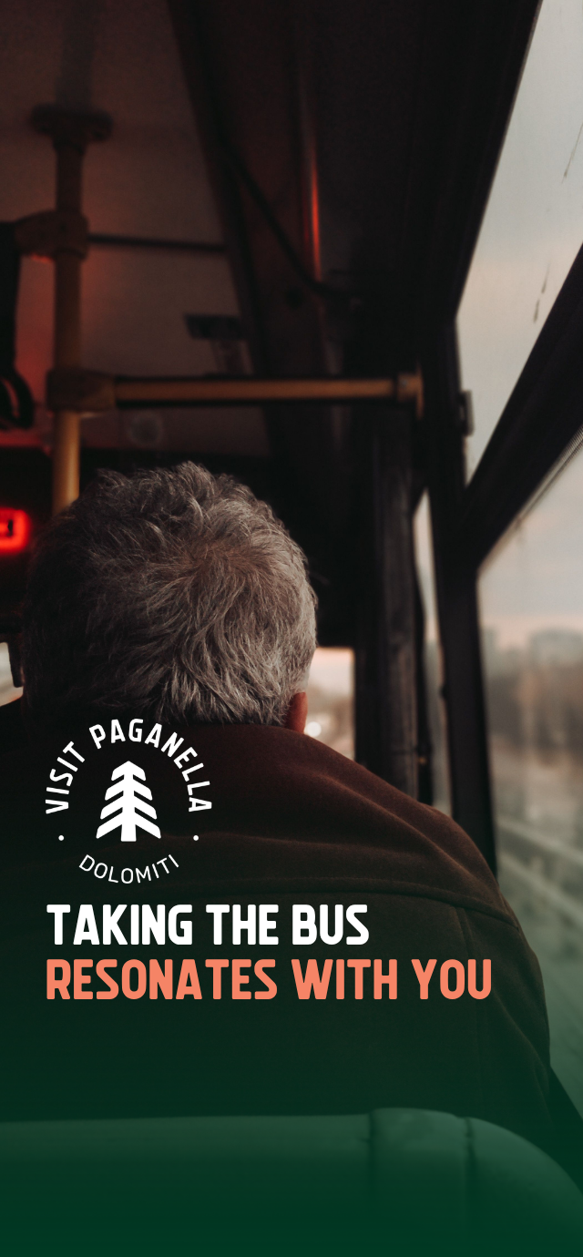 A view from the inside of a bus, looking over the shoulder of a gray-haired passenger who is looking out the window. The atmosphere is characterized by warm lighting and shadows. In the lower left, on a dark green gradient, there is a circular white logo with a stylized pine tree in the center and the words "VISIT PAGANELLA" and "DOLOMITI". Below the logo, the following text is written in uppercase: "TAKING THE BUS" (in white) "RESONATES WITH YOU" (in peach) | © Tuğba Özsoy